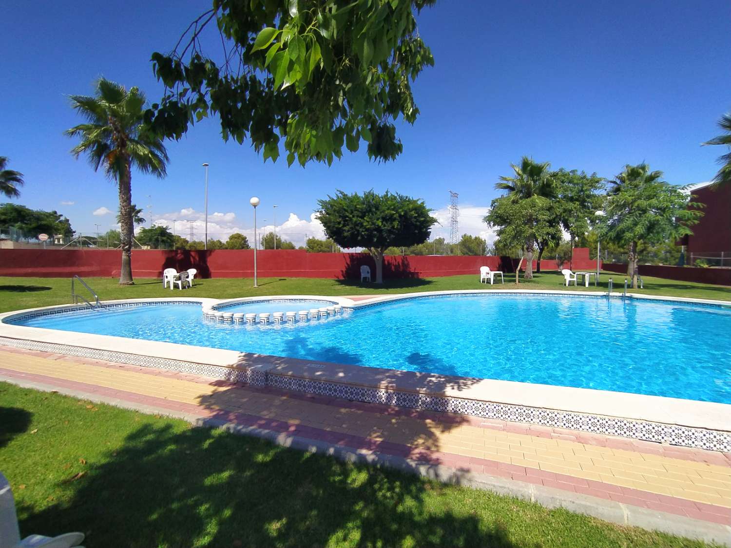 Appartement au rez-de-chaussée avec 2 chambres et piscine commune.